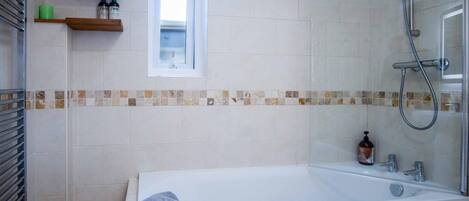 A modern bathroom with a bathtub, a shower, and a window.