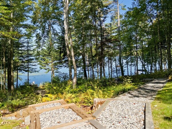 Une zone boisée avec un sentier de gravier menant à un plan d’eau.