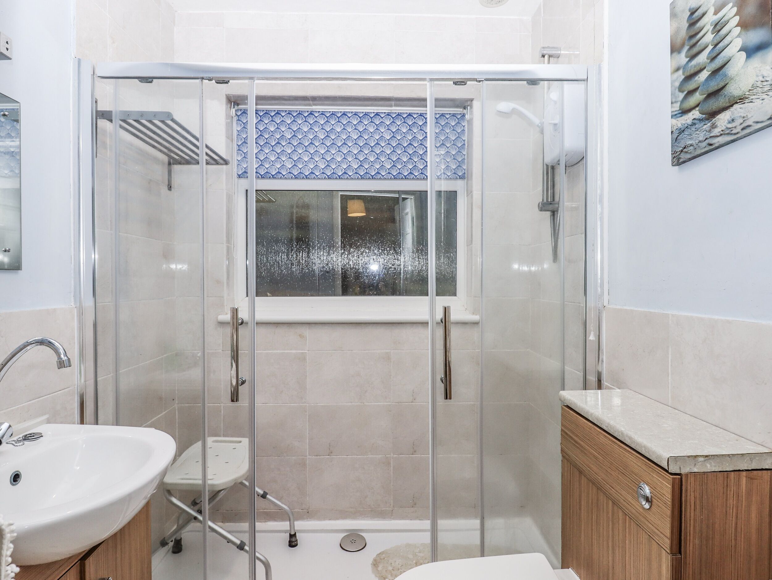A modern bathroom with a glass-enclosed shower, a sink, and a vanity.