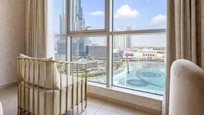 Une chambre située dans un immeuble de grande hauteur, dotée d’une grande fenêtre donnant sur un paysage urbain et une piscine.