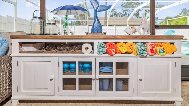 Een witte houten bar met glazen potten, een blauwe walvissculptuur en kleurrijke handdoeken.