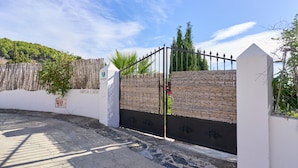 A gated entrance with a wooden fence, a metal gate, and a sign with the number 411.