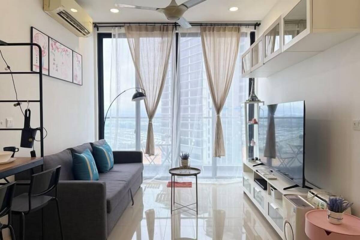 Una sala moderna con sofá, televisión y comedor.