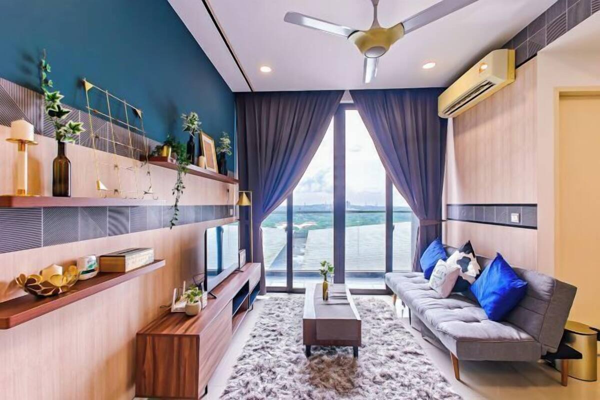 Una sala moderna con sofá, mesa de centro, televisor y objetos decorativos.