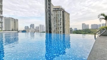 Piscina com paisagem urbana ao fundo.