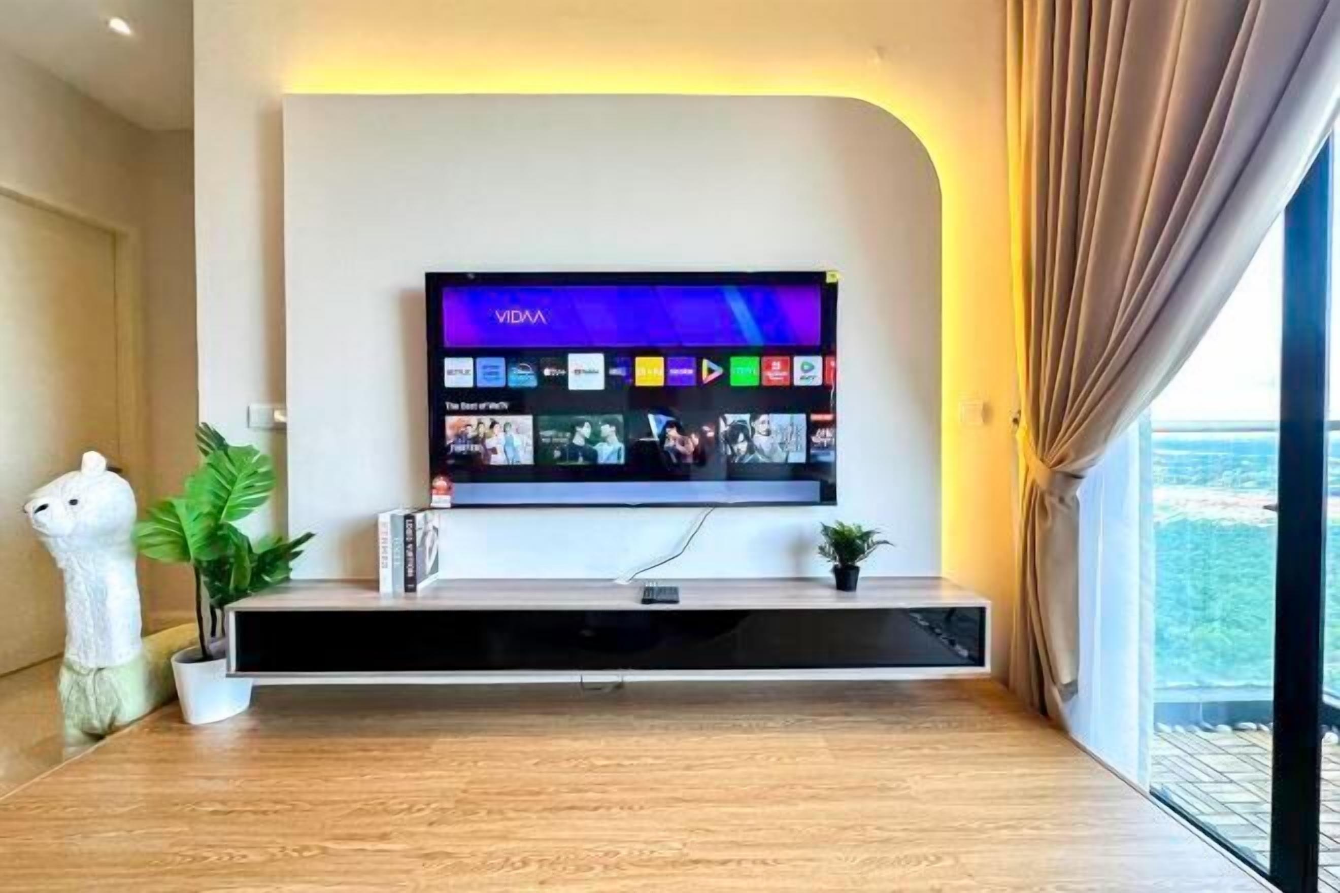 A modern living room with a mounted flat-screen TV displaying a VIVA app interface.