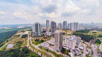Um complexo de edifícios residenciais altos, com várias torres, rodeado por áreas verdes e estradas.
