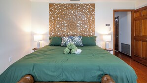 A neatly made bed with a green bedspread, two pillows, and a decorative headboard. - Cozy 4bed 2bth villa - daytona beach  (Deltona)