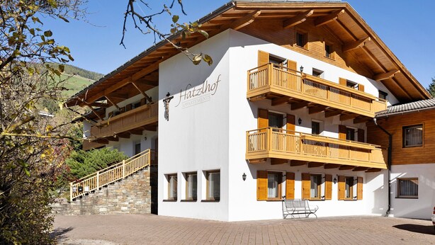 Un immeuble à plusieurs étages, doté de balcons en bois et d’un escalier en pierre.