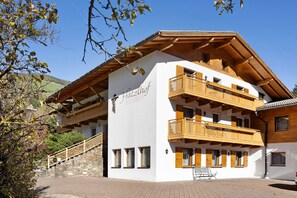 Un immeuble à plusieurs étages, doté de balcons en bois et d’un escalier en pierre.