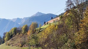 Um sistema de teleférico numa encosta, com montanhas ao fundo.