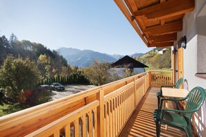 A wooden balcony with a view of mountains, a table, and chairs. - Apartment 'Hatzlhof Nr 2' with Mountain View, Shared Terrace and Wi-Fi (Vipiteno)
