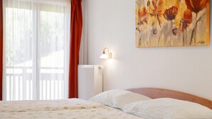 Ein Schlafzimmer mit einem Bett, einem Heizkörper, einer Wandleuchte und einem Bild.