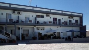 A two-story building with a flat roof, multiple balconies, and a paved courtyard. - Guest House RSA by Umbral (Loulé)