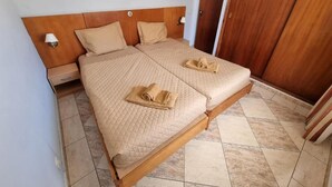A double bed with a wooden headboard, two pillows, and a quilted bedspread. There are two bedside tables with lamps, a wooden wardrobe, and a framed picture on the wall. - Cerro Atlântico by Umbral (Albufeira)