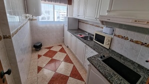 A kitchen with white cabinets, a microwave, a toaster, and a sink. - Cerro Atlântico by Umbral (Albufeira)