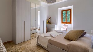 A bedroom with a bed, a wardrobe, a desk, and a window with a view. - Holiday Home 'L'aia Dì Trippa All'Aria Mugello' with Private Garden and Wi-Fi (Borgo san Lorenzo)
