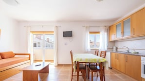 Un espacio habitable compacto con comedor, kitchenette y sofá.