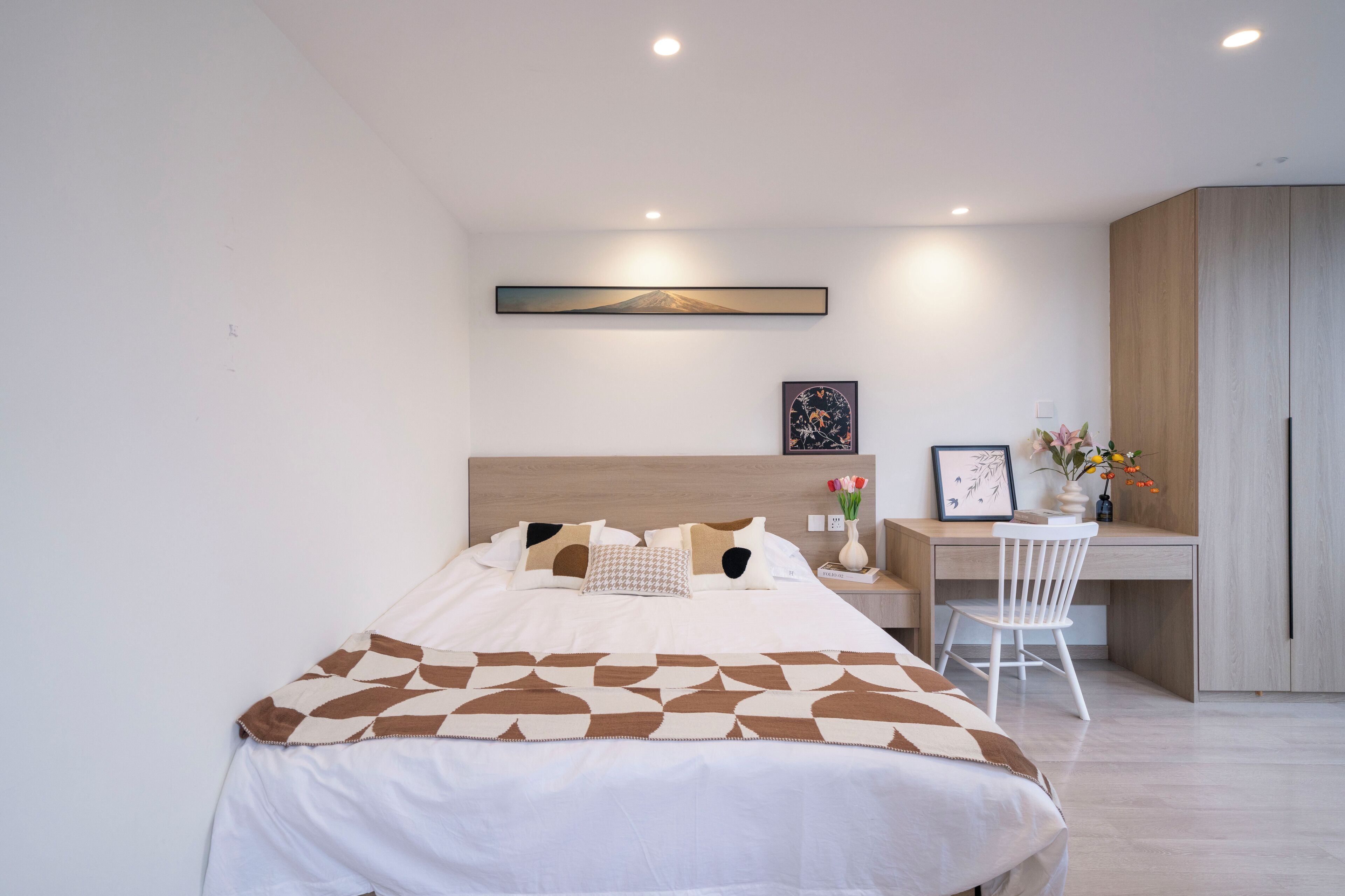 A modern bedroom with a bed, a desk, and a chair.
