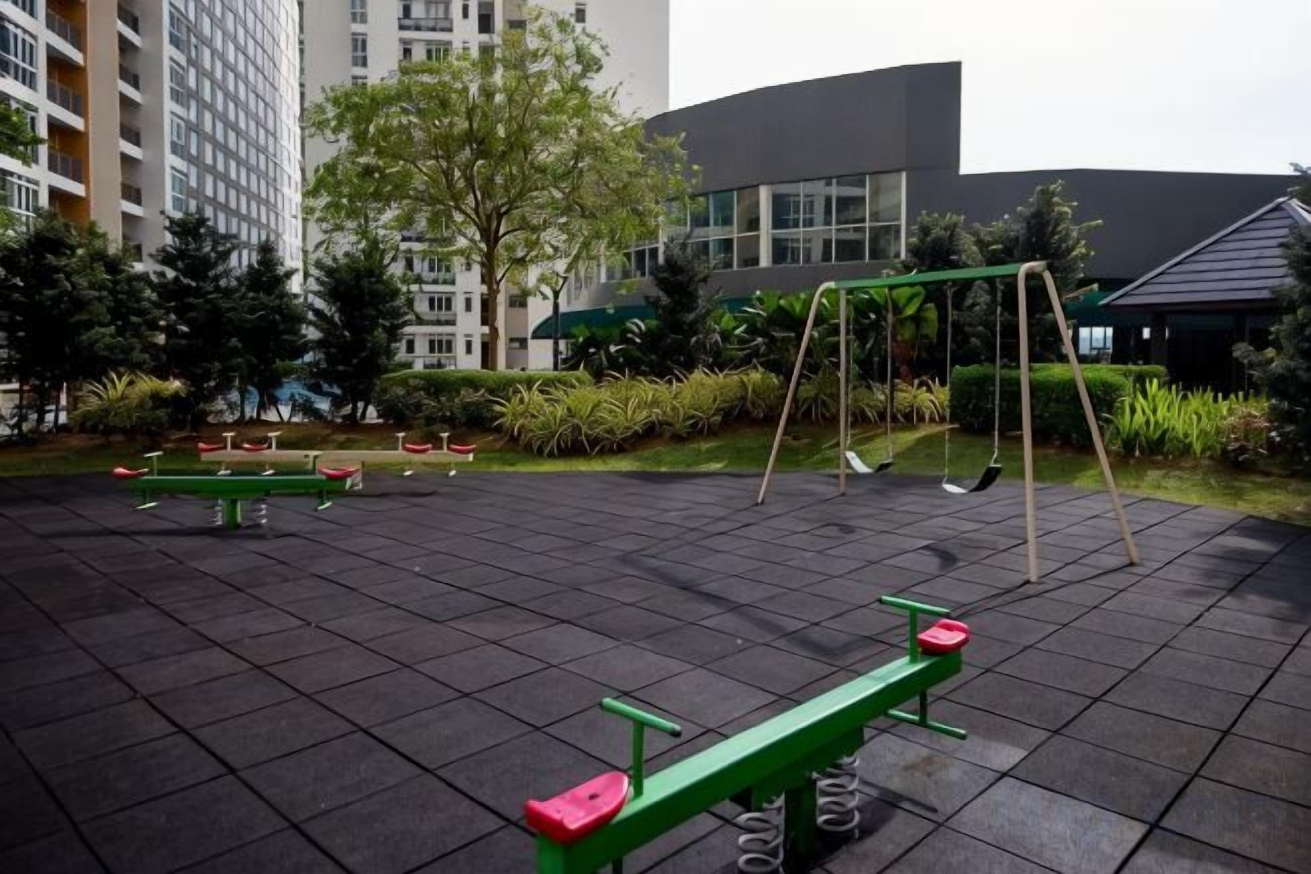 An outdoor exercise area with benches, a swing set, and exercise equipment.