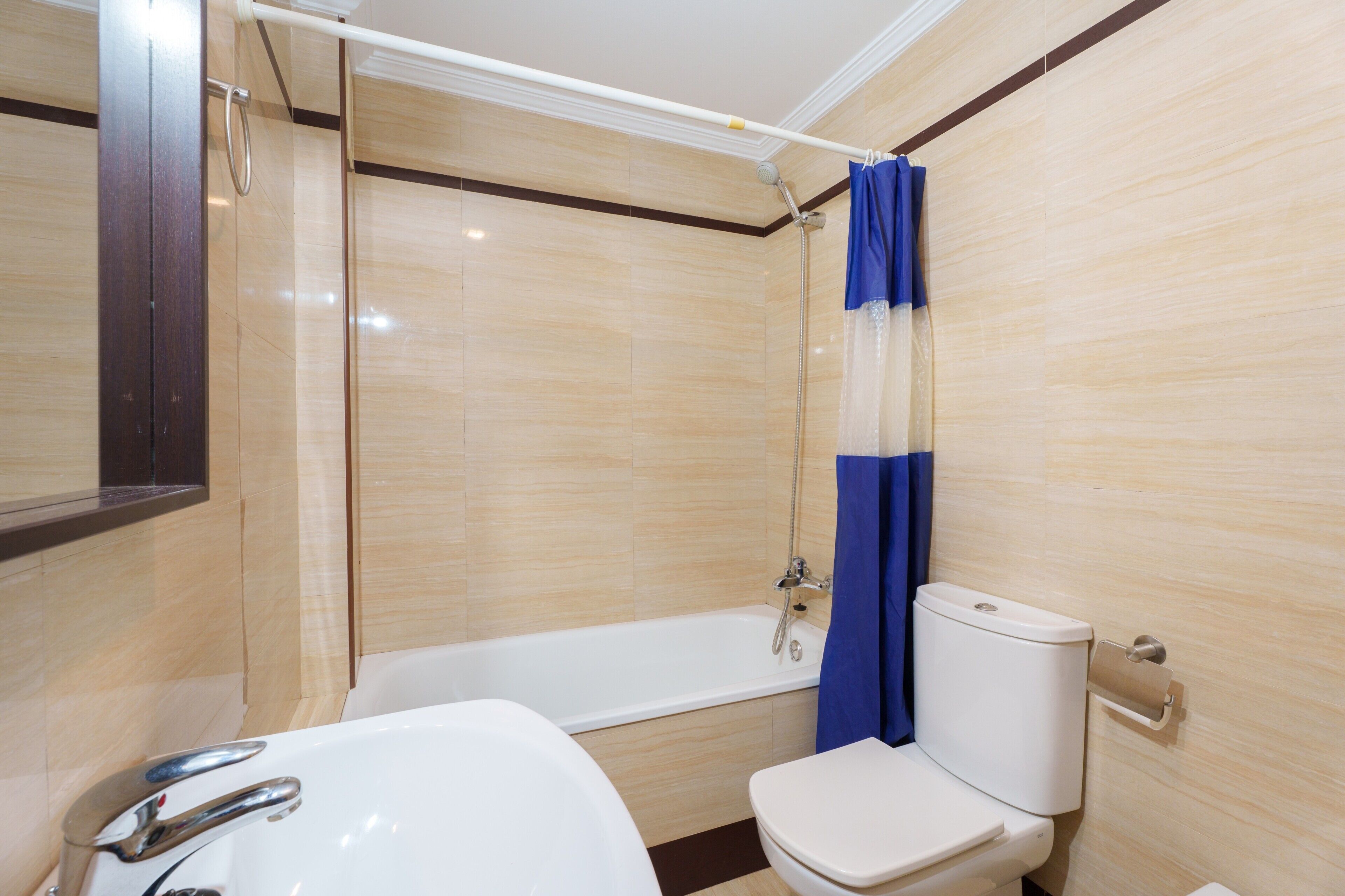 Une salle de bain avec une baignoire, des toilettes et un rideau de douche.