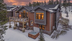 A modern two-story lodge with a hot tub and outdoor seating, surrounded by snow and trees. - Modern Luxury | Mountain Views | Hot Tub + Shuttle - Cherrybrook Chalet (Breckenridge)