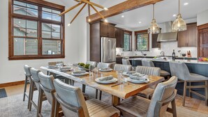A spacious kitchen with a central island, modern appliances, and ample natural light from large windows. - Modern Luxury | Mountain Views | Hot Tub + Shuttle - Cherrybrook Chalet (Breckenridge)