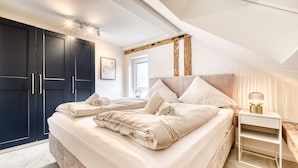 A bedroom with a bed, bedside table, and wardrobe. - Ferienwohnung Alpen Zentral (Bludenz)