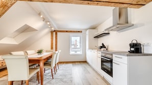 A modern kitchen with white cabinets, a built-in oven, and a coffee machine. - Ferienwohnung Alpen Zentral (Bludenz)