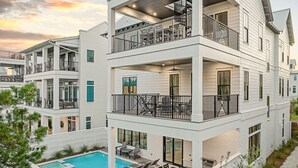 Un edificio de varios pisos con balcones, piscina y zonas de estar al aire libre.