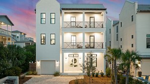 Un edificio residencial de varios pisos con garaje, balcones y entrada para vehículos.