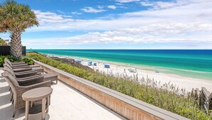A beach view from a balcony with wicker furniture and a palm tree. - Seaside Serenity|Gulf Front|Private Beach Access|Private Pool (Seagrove Beach)