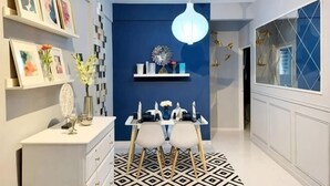 Een moderne keuken met een blauwe accentmuur, een plafondventilator en een eetgedeelte met een vloer met een geometrisch patroon.