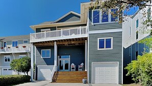 A two-story residential building with a front porch, a balcony, and a garage. - Shady Beaches by Topsail Realty (Holly Ridge)