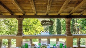 Un espace extérieur aménagé pour prendre les repas, avec vue sur une piscine et une végétation luxuriante.