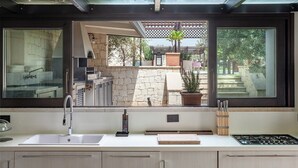 A modern kitchen with a large window, a sink, and a stove.