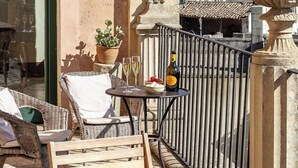 A terrace with wicker furniture, a table with a bottle and glasses, and a potted plant. - Palazzo Colucci - Four Bedroom Villa, Sleeps 8 (Minervino di Lecce)