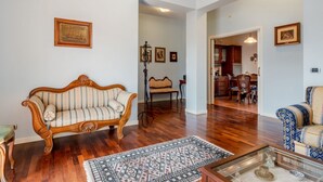 A living room with a wooden sofa, a patterned rug, and a coffee table.