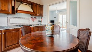 A kitchen with wooden cabinets, a round dining table, and a decorative vase.