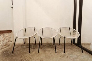 Three white chairs with black legs against a plain wall. - 5BR Ruma Papanz Moden 30Pax (Melaka)