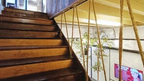 A wooden staircase with rope handrails, leading to a covered outdoor area with a metal railing. - 5BR Ruma Papanz Moden 30Pax (Melaka)