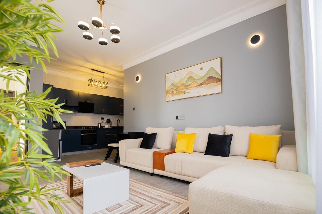 A modern living room with a sofa, a coffee table, and a painting on the wall.