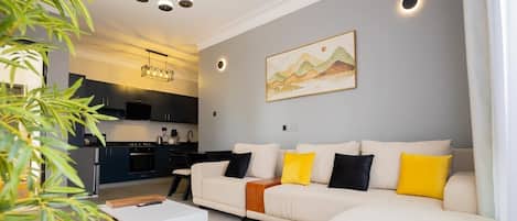 A modern living room with a sofa, a coffee table, and a painting on the wall.