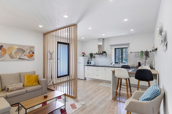A modern apartment with a living room, kitchen, and dining area.