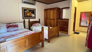 Una camera da letto con un letto in legno, una panca, un armadio e un quadro appeso al muro.
