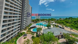 A high-rise hotel with multiple balconies, a swimming pool, and a view of the ocean. - Santa Marina Luxury Stay - Ocean View (Santa Marta)