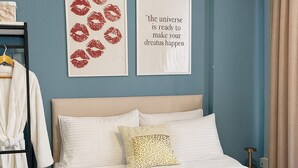 A neatly made bed with white linens, a mustard-colored throw blanket, and two folded towels on the bedside table. - Casafra (Istanbul)