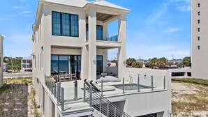 Een modern meerlaags gebouw met een glazen balkon en een terras.