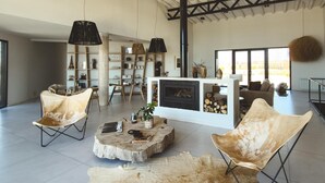 Un salón amplio con sillones de cuero, una mesa de centro y una chimenea.