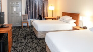A hotel room with two beds, a desk, a chair, a TV, and a lamp. - Best Inn of Manning (Manning)